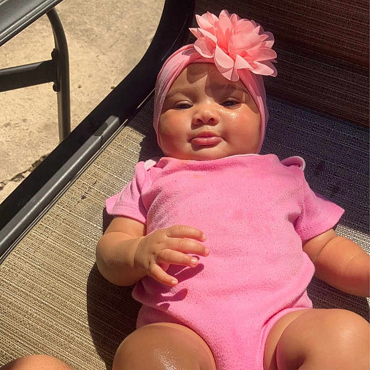 Maria is registered to the contest to win money with this photo: accessories, baby, cap, chair, clothing, dress, face, flower, furniture, glasses, hat, head, person, photography, plant, portrait, shorts, sitting, swimwear, toy