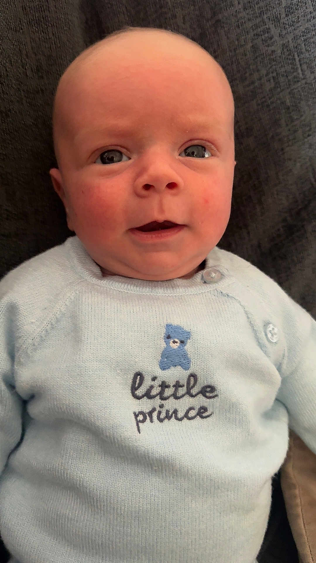 George joined the competition — help win amazing prizes! baby, infant, sweater, blue, face, eyes, mouth, person, child, cute, portrait, knitwear, clothing, childrenswear, closeup, skin, newborn, head, expression, indoors