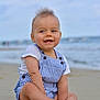 Charles participe au concours pour gagner de l'argent avec cette photo : baby, child, smiling, beach, sand, ocean, water, sky, clouds, romper, striped_clothing, barefoot, sitting, happy, cute, portrait, outdoor, summer, young, person