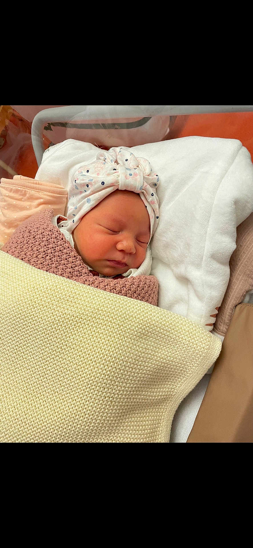 Alma participe au concours pour gagner de l'argent avec cette photo : newborn, baby, sleeping, blanket, headband, hospital_bassinet, cozy, infant, soft_lighting, cute, peaceful, wrapped, sleep, child, person, knit_blanket, white_blanket, pink, fabric, indoors