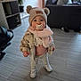 Alma a rejoint le concours — aidez-le/la à gagner de superbes lots ! toddler, child, indoors, pacifier, hat, pom_poms, scarf, pink, coat, shoes, floor, living_room, couch, plant, modern, standing, cute, portrait, baby, person