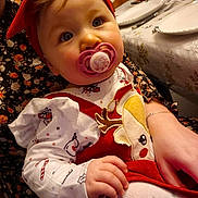 Alma participe au concours pour gagner de l'argent avec cette photo : baby, child, pacifier, red_headband, christmas_outfit, reindeer_design, holiday, table_setting, plates, glasses, hand, sitting, cute, indoor, person, festive, white_tights, floral_dress, closeup, face