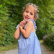 Liyah a rejoint le concours — aidez-le/la à gagner de superbes lots ! child, girl, smile, portrait, outdoor, nature, greenery, dress, blue, stripes, cute, young, happy, pathway, sunlight, playful, innocence, posing, short_sleeves, braids