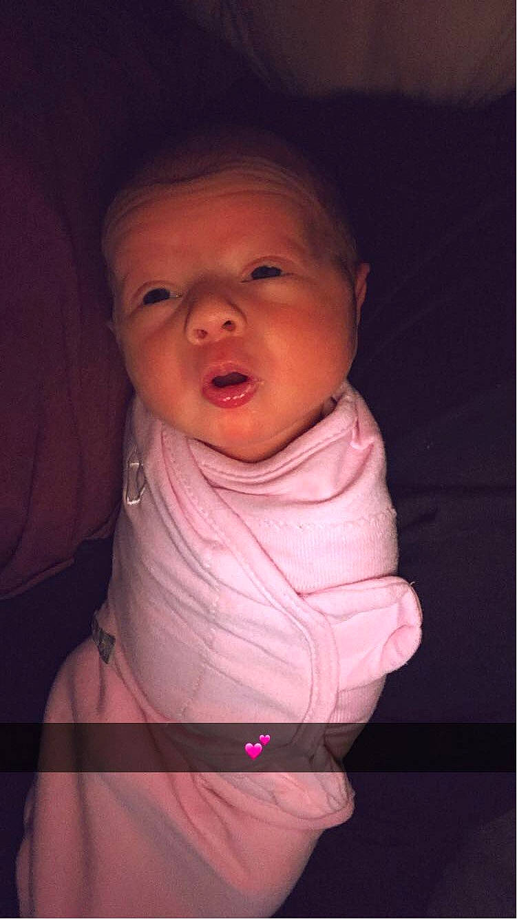 Layla is registered to the contest to win money with this photo: baby, baby_products, baby_toddler_clothing, cheek, comfort, eyebrow, flash_photography, gesture, happy, iris, lip, magenta, mouth, neck, nose, person, pink, skin, sleeve, t_shirt