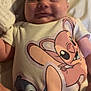baby, cartoon_characters, child, closeup, clothing, cozy, cute, face, happy, head, indoor, infant, lying_down, newborn, onesie, person, skin, smiling, soft_lighting, young_child