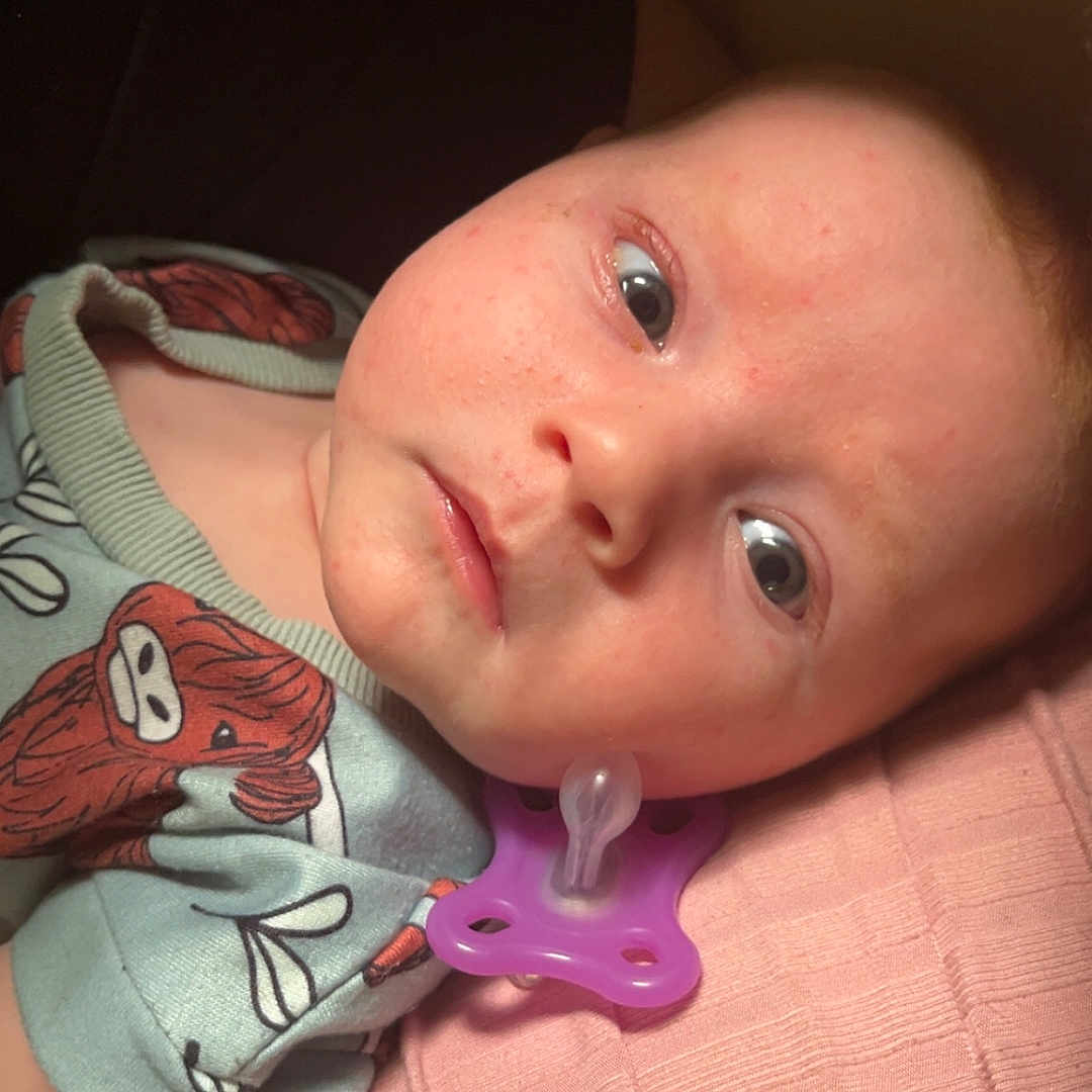 Emone joined the competition — help win amazing prizes! baby, blanket, blue, child, closeup, clothing, cute, expression, face, head, indoors, infant, lying_down, pacifier, pink, portrait, resting, skin, texture, young