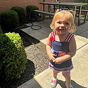 Daphne Daniel is registered to the contest to win money with this photo: backyard, child, clothing, face, female, fence, footwear, head, hedge, nature, outdoors, path, person, photography, plant, portrait, pottedplant, shoe, shorts, yard
