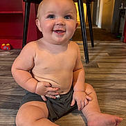 Anthony joined the competition — help win amazing prizes! baby, child, smiling, sitting, floor, indoor, shorts, bare_chest, toy, table, legs, hands, face, happy, cute, skin, blue_eyes, furniture, home, expression