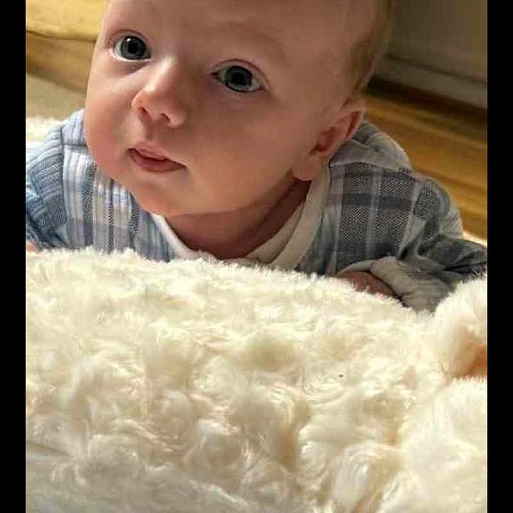 Noah-David joined the competition — help win amazing prizes! baby, blanket, child, clothing, cozy, curious, cute, eyes, face, floor, head, indoor, infant, lying_down, newborn, person, plaid, portrait, skin, soft