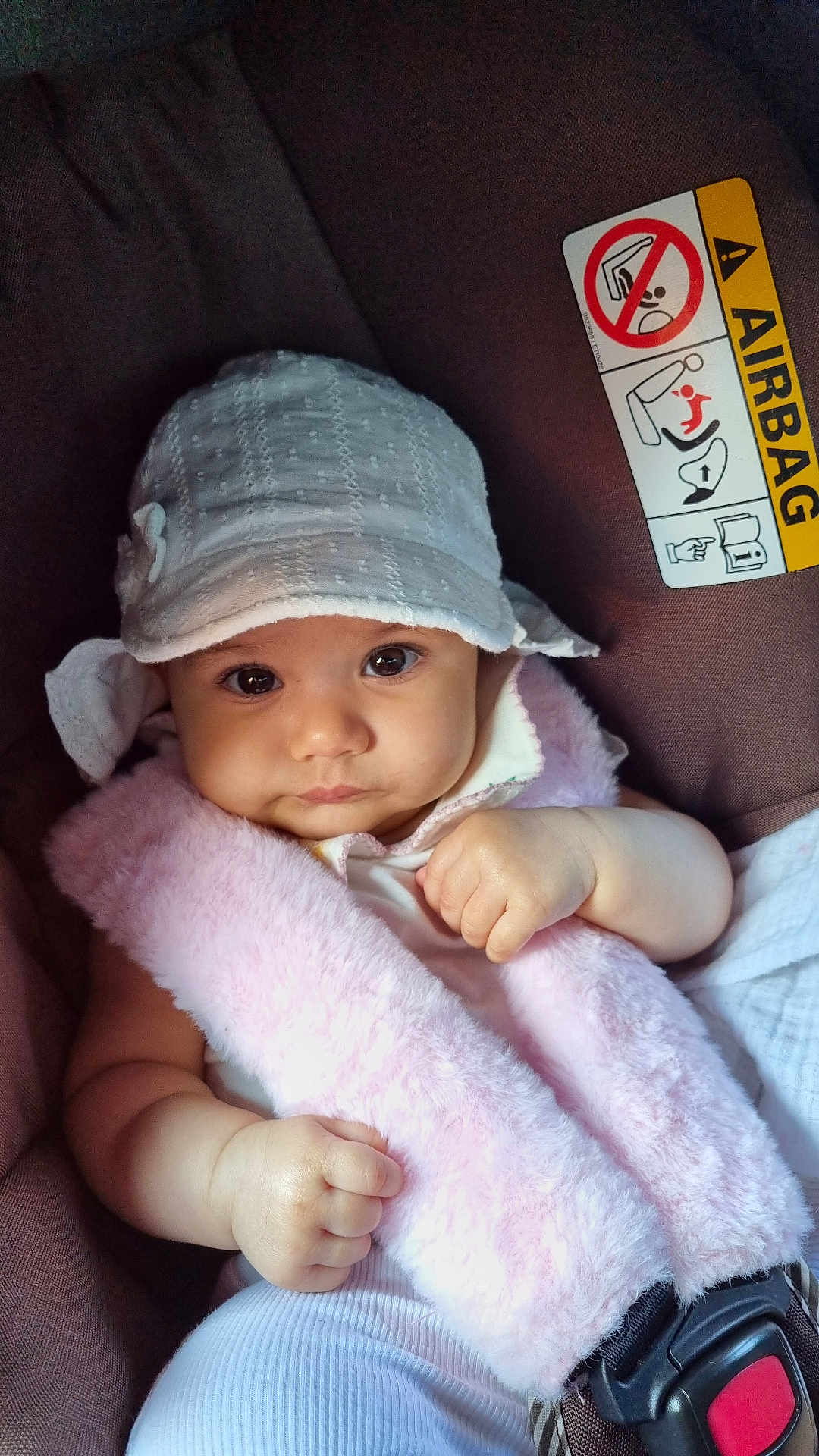 Hala joined the competition — help win amazing prizes! baby, infant, car_seat, hat, pink, white, strap, safety_belt, face, cute, child, seatbelt, car, warning_label, airbag, clothing, portrait, hand, skin, young