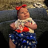 baby, blanket, blue_skirt, carpet, child, clothing, cozy, cute, hand_motion, headband, home, indoor, infant, laying_down, person, portrait, red_bow, smiling, stars_pattern, white_shirt