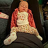 Saige is registered to the contest to win money with this photo: baby, sleeping, infant, person, clothing, floral_pattern, socks, jacket, lap, indoor, couch, legs, feet, relaxation, comfort, home, casual, rest, soft, cute