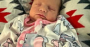 Saige is registered to the contest to win money with this photo: baby, sleeping, onesie, animal_print, blanket, pattern, indoors, cozy, child, infant, cute, soft, peaceful, hand, pink, white, gray, red, portrait, resting