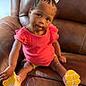 Elyse joined the competition — help win amazing prizes! braided_hair, casual_clothing, child, comfortable, curious, cute, furniture, head_tilt, indoor, leather_couch, looking_at_camera, person, pink_shirt, portrait, sitting, small_child, toddler, white_bow, yellow_shoes, young_child