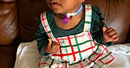 Elyse is registered to the contest to win money with this photo: blanket, brown_couch, child, colorful_clothing, cute, expression, hair_ties, home, indoor, medical_device, person, plaid_dress, portrait, red_shoes, sitting, soft_focus, toddler, tracheostomy, white_tights, young_child