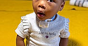 Elyse joined the competition — help win amazing prizes! baby, child, cross_legged, curious_expression, cute, earrings, face, headband, indoor, love_my_family, person, pink_bow, purple_pants, sitting, small_ears, text_on_shirt, toddler, white_shirt, white_socks, yellow_background
