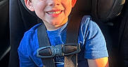 Beau is registered to the contest to win money with this photo: child, boy, car_seat, smile, blue_shirt, sunlight, seatbelt, car_interior, happy, young, portrait, sitting, face, hair, window, daylight, safety, casual_clothing, indoors, cute