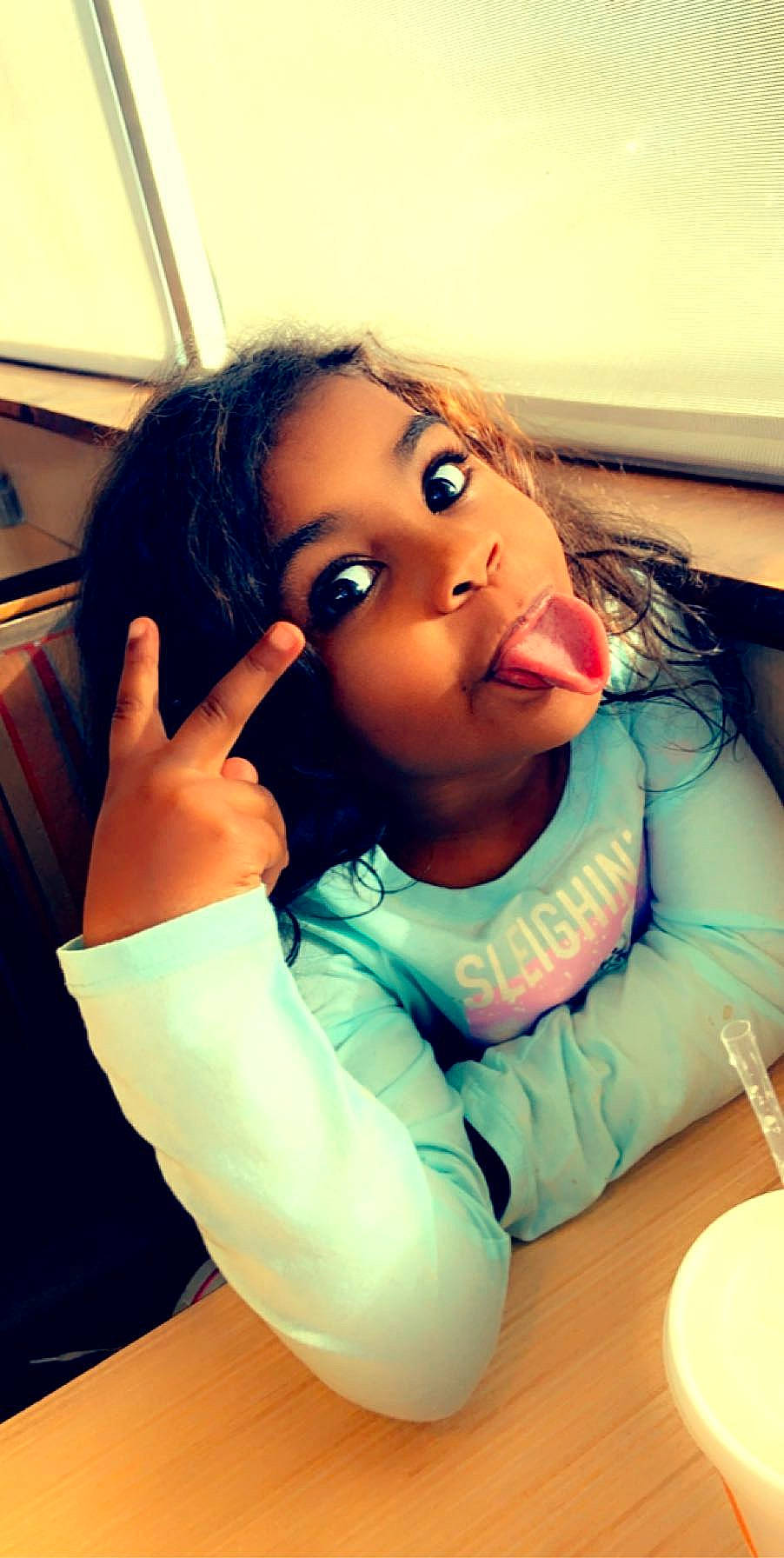 Izabella joined the competition — help win amazing prizes! black_hair, chair, child, eye, eyelash, finger, fun, gesture, hair, hand, happy, lip, long_hair, mouth, neck, nose, person, skin, t_shirt, tableware