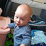 Atticus is registered to the contest to win money with this photo: toddler, child, blue_onesie, indoor, playpen, blanket, plastic_container, baby, curious, motion, hand, floor, soft_toys, home, young_child, person, clothing, infant, room, casual