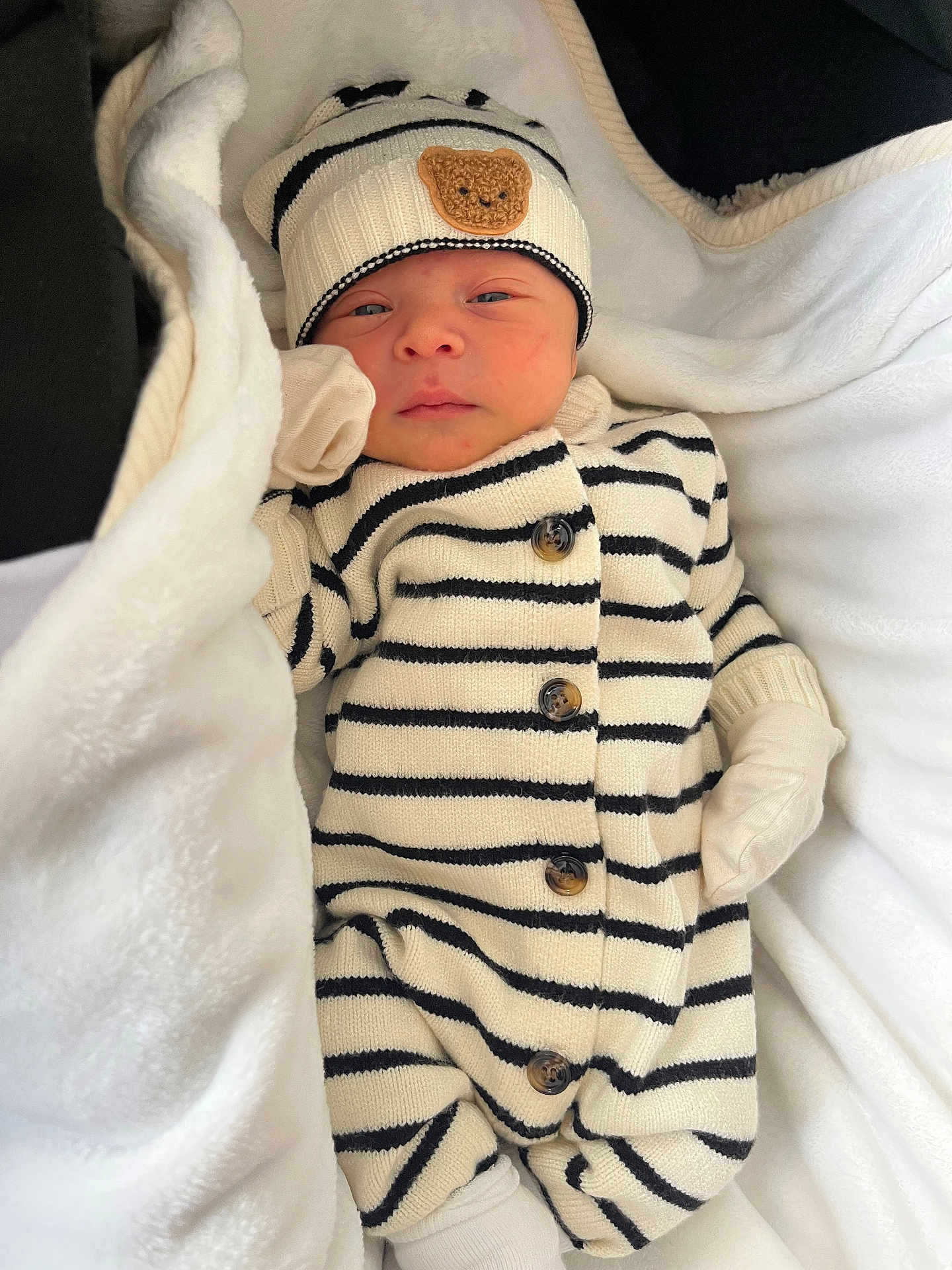 Samuel participe au concours pour gagner de l'argent avec cette photo : newborn, baby, infant, blanket, striped_clothing, hat, bear_patch, mittens, cozy, sleepy, cute, portrait, soft, warm, lying_down, small, child, knitwear, white, black_stripes