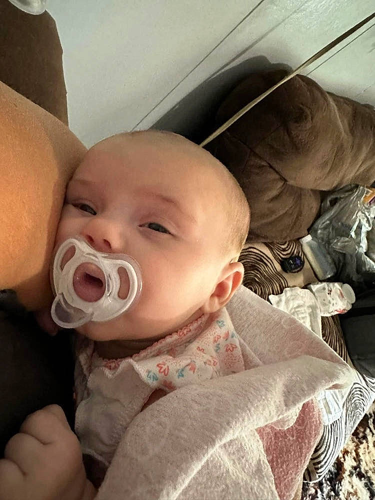 Charlotte is registered to the contest to win money with this photo: baby, baby_products, baby_toddler_clothing, cheek, comfort, ear, eyebrow, eyelash, gesture, happy, iris, linens, lip, mouth, neck, nose, person, sitting, skin, sleeve