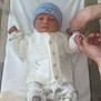 baby, newborn, infant, hospital, bed, blanket, hat, knitwear, pants, animal_print, hands, person, lying_down, white, blue, cute, tender, soft, sleepwear, child