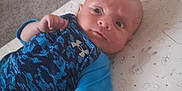 Archie joined the competition — help win amazing prizes! baby, infant, blue_clothing, onesie, lying_down, carpet, changing_pad, animal_print, hand, face, expression, indoor, toy, purple_toy, furniture, floor, person, newborn, child, cute