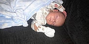 Archie is registered to the contest to win money with this photo: animal_print, baby, blanket, child, clothing, comfort, couch, cozy, cute, face, indoors, infant, newborn, pajamas, peaceful, portrait, resting, sleeping, soft, toddler
