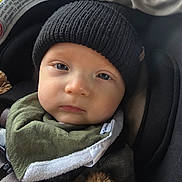 Weston is registered to the contest to win money with this photo: baby, infant, child, car_seat, beanie, hat, bib, face, eyes, cheeks, closeup, portrait, seatbelt, buckle, blanket, fur, cozy, warm, expression, clothing