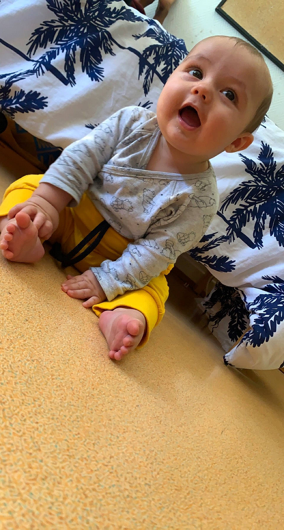 Kenzo participe au concours pour gagner de l'argent avec cette photo : baby, baby_toddler_clothing, cheek, child, facial_expression, finger, floor, flooring, foot, fun, happy, human_body, human_leg, nose, outerwear, person, sitting, skin, sleeve, toddler