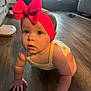 Mylee joined the competition — help win amazing prizes! baby, crawling, headband, red_bow, floor, wooden_floor, living_room, furniture, couch, curious, child, indoor, person, young_child, skin, face, eyes, mouth, clothing, home