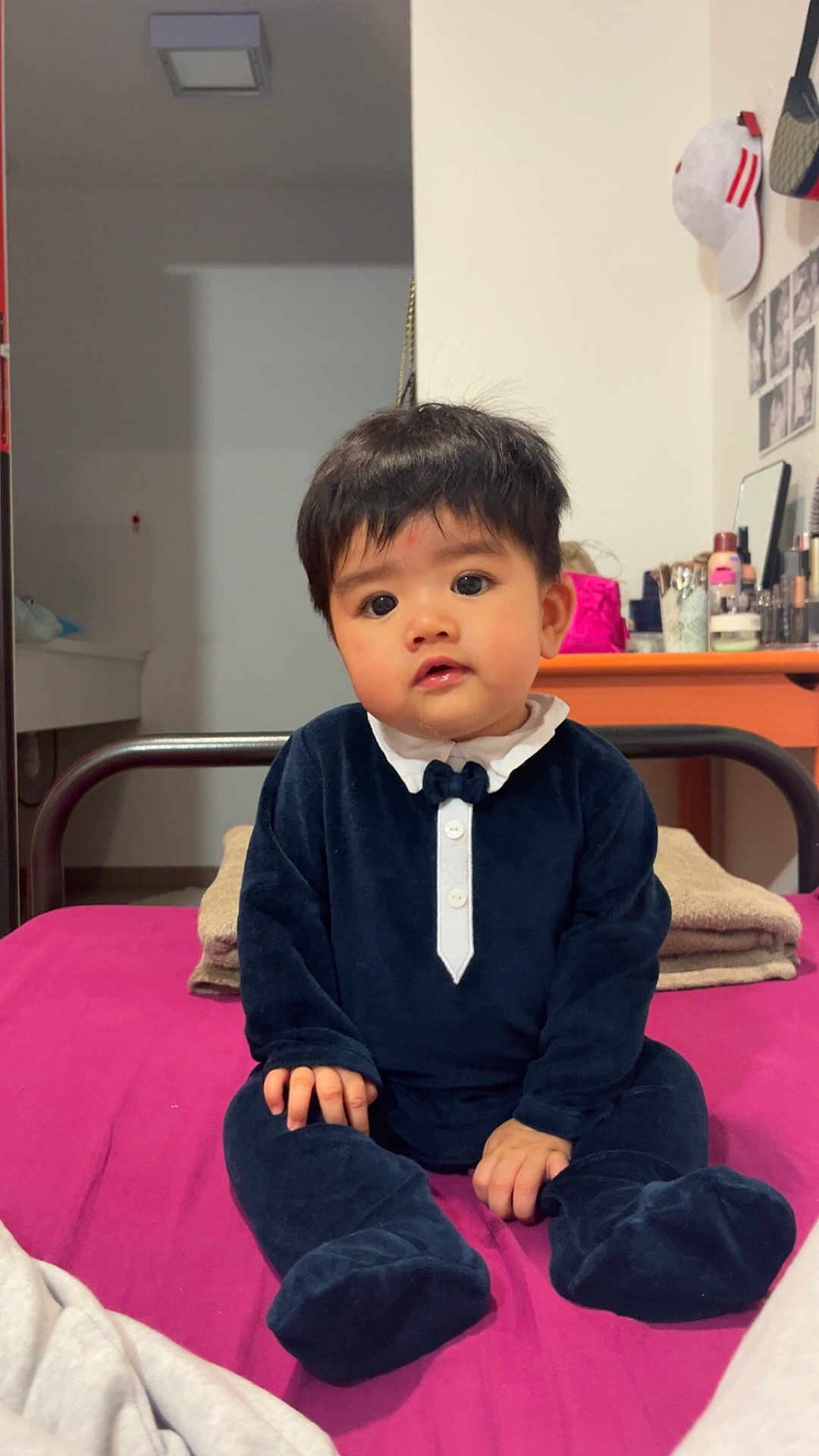 Kent participe au concours pour gagner de l'argent avec cette photo : baby, infant, child, tuxedo_onesie, bed, pink_bedspread, blanket, indoor, curious_expression, sitting, toddler, furniture, vanity, mirror, cosmetics, hat, photography, portrait, cute, young