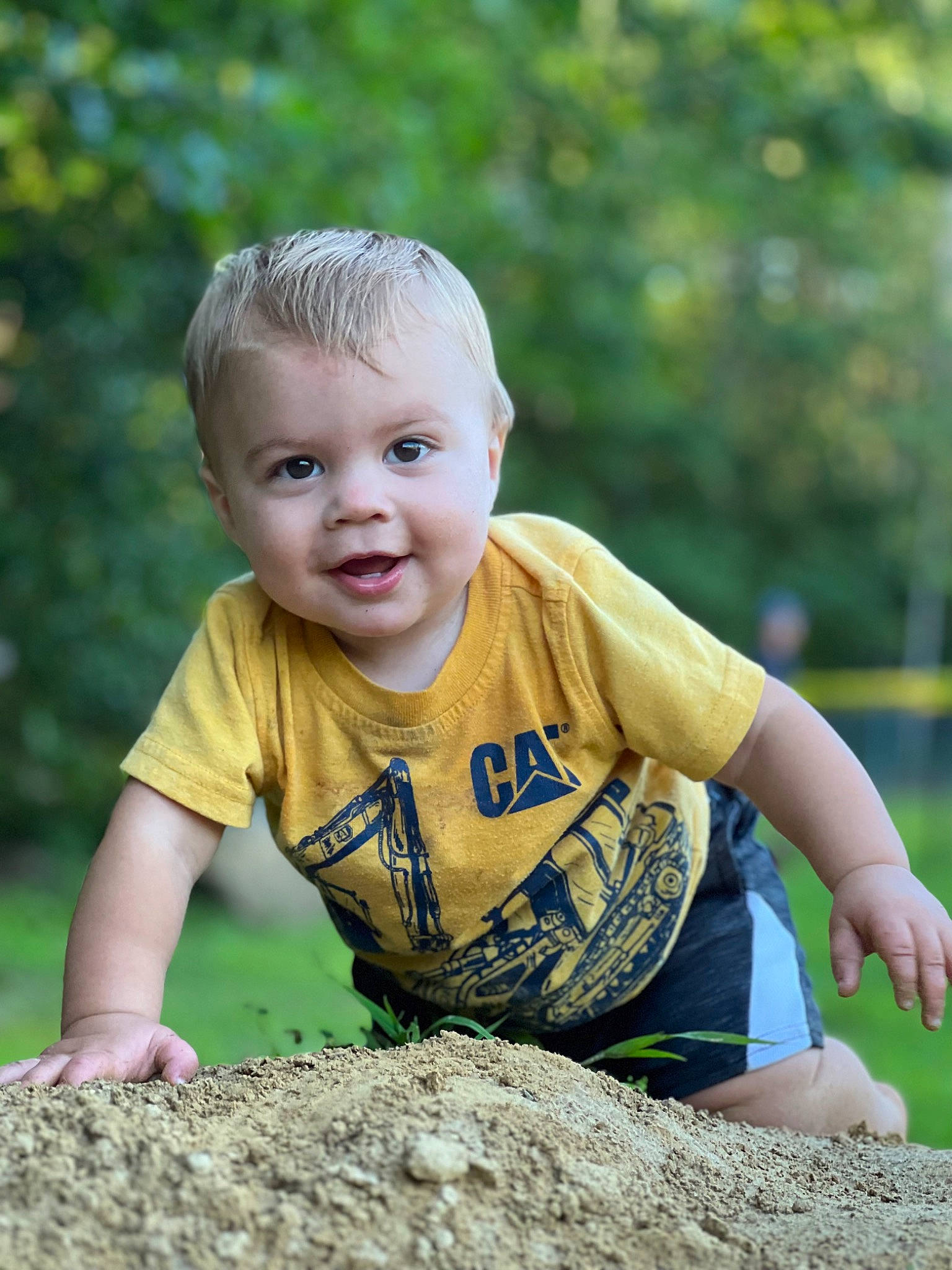 Teddy is registered to the contest to win money with this photo: baby, baby_toddler_clothing, child, fun, grass, grass_family, hairstyle, happy, leisure, people_in_nature, person, play, recreation, sitting, sleeve, smile, soil, spring, t_shirt, toddler