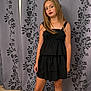 attitude, black_dress, casual, child, confident, curtain, dress, fashion, floor_tiles, floral_pattern, girl, indoors, long_hair, person, portrait, posing, red_lipstick, standing, young, youth