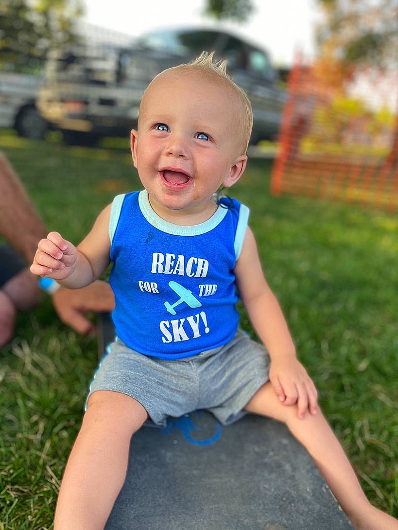 Krew is registered to the contest to win money with this photo: baby, baby_toddler_clothing, blue, child, facial_expression, fun, grass, happy, laugh, people, person, photography, play, sitting, skin, smile, summer, t_shirt, toddler, vacation