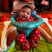 Myreane is registered to the contest to win money with this photo: baby, smiling, pajamas, polka_dot, baby_walker, toy, stuffed_animal, floor, wood_floor, string_lights, holiday_decor, welcome_sign, face, indoor, child, feet, footwear, happy, infant, cozy