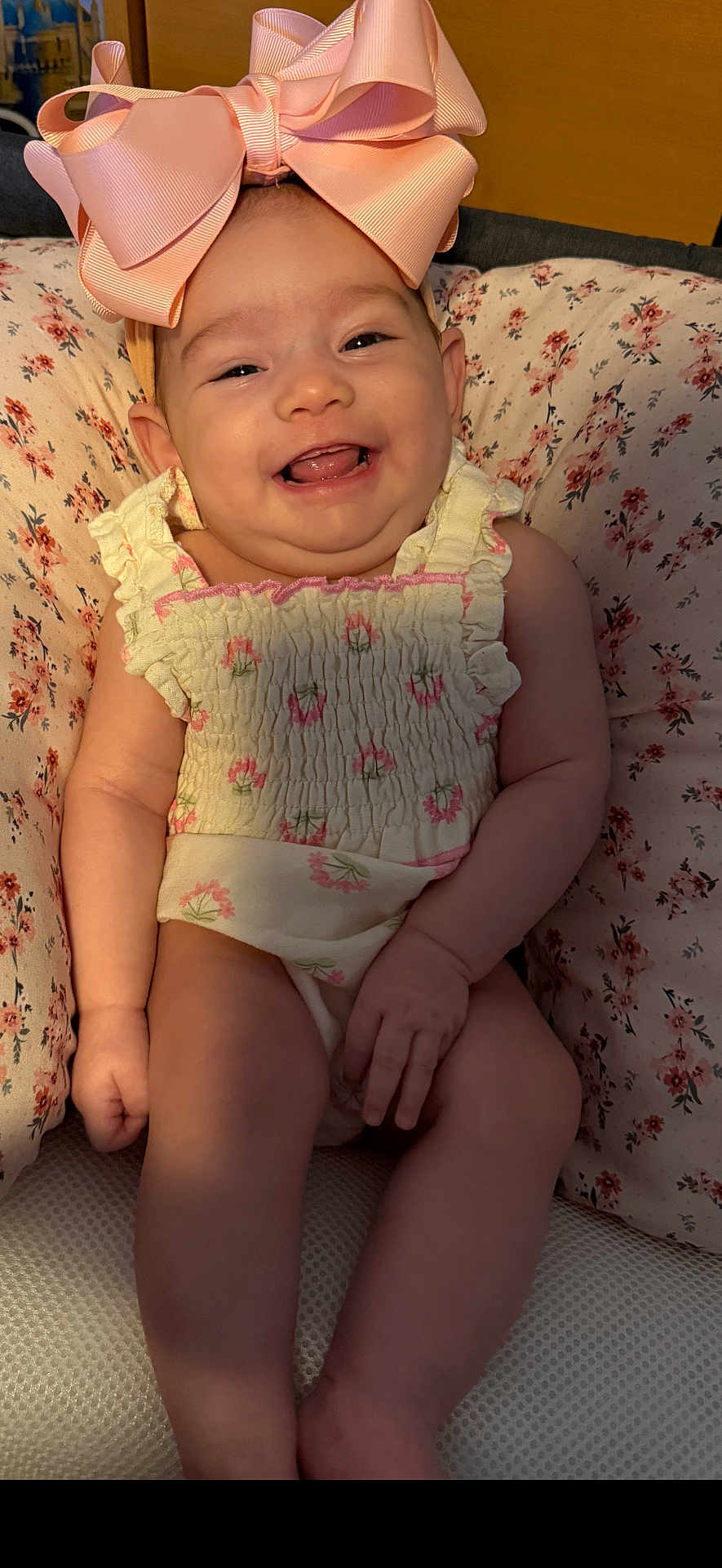 Ariyah Kassing is registered to the contest to win money with this photo: baby, bow, child, closeup, cushion, cute, expression, floral_outfit, happy, headwear, indoor, infant, patterned_cushion, person, pink_bow, portrait, sitting, skin, smiling, young_child