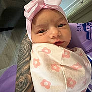 Ariyah Kassing is registered to the contest to win money with this photo: baby, infant, pink_bow, blanket, tattoo, arm, indoor, person, face, headband, sleepy, curious, floral_pattern, closeup, newborn, soft_lighting, cuddle, human, wrapped, portrait