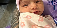 Ariyah Kassing is registered to the contest to win money with this photo: arm, baby, blanket, closeup, cuddle, curious, face, floral_pattern, headband, human, indoor, infant, newborn, person, pink_bow, portrait, sleepy, soft_lighting, tattoo, wrapped