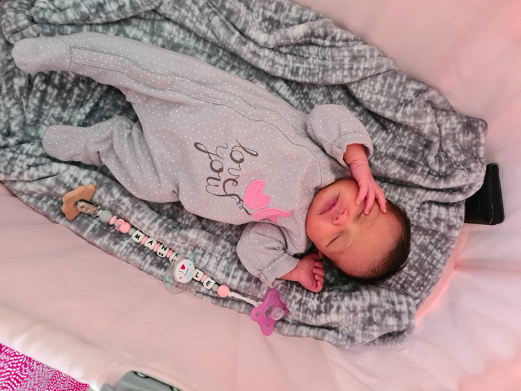 Manelle participe au concours pour gagner de l'argent avec cette photo : abdomen, arm, baby, bed, child, comfort, elbow, finger, gesture, grey, joint, linens, magenta, pattern, person, pink, sleeve, t_shirt, textile, thigh