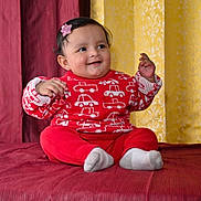 Utkarsha is registered to the contest to win money with this photo: baby, child, smiling, red_sweater, car_pattern, red_pants, white_socks, sitting, bedspread, maroon_curtain, yellow_curtain, indoor, happy, portrait, cute, infant, person, clothing, hairclip, decor