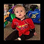 Cooper joined the competition — help win amazing prizes! child, toddler, red_jersey, cardinals, sitting, carpet, toy_car, blue_toy, indoor, curious_expression, blonde_hair, person, casual_clothing, floor, playroom, young_child, wide_eyes, home, portrait, cute