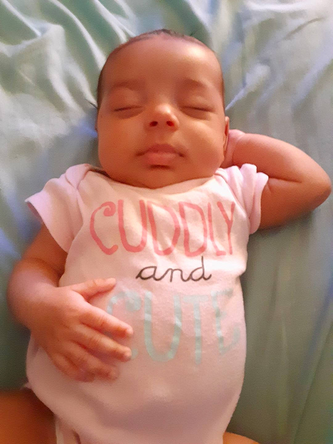 Niyomi is registered to the contest to win money with this photo: baby, baby_toddler_clothing, cheek, chin, comfort, eye, finger, gesture, hand, happy, head, human_body, lip, neck, nose, person, pink, skin, sleeve, stomach