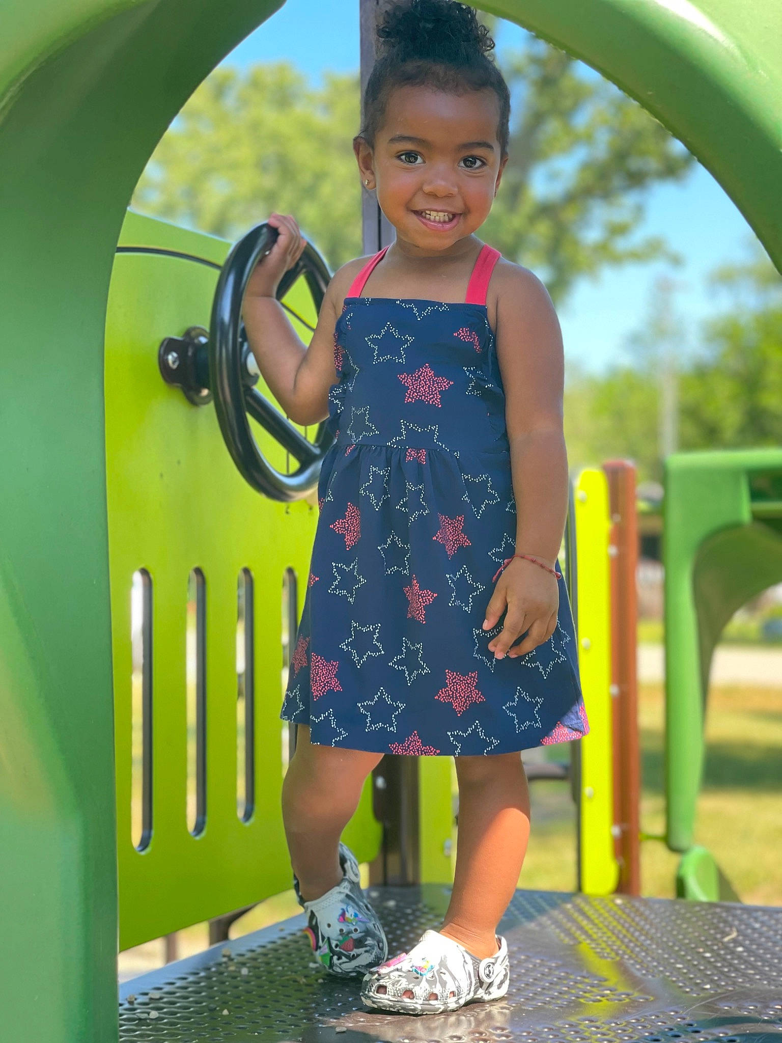 Jordyn is registered to the contest to win money with this photo: baby_toddler_clothing, child, dress, electric_blue, eye, facial_expression, fun, grass, happy, joy, leisure, person, photograph, public_space, recreation, smile, snapshot, standing, summer, toddler