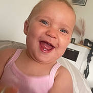 Victoire a rejoint le concours — aidez-le/la à gagner de superbes lots ! baby, bed, blanket, cheerful, child, closeup, cute, face, furniture, happy, head, home_interior, indoor, person, pink_tank_top, portrait, skin, smiling, toddler, young_child