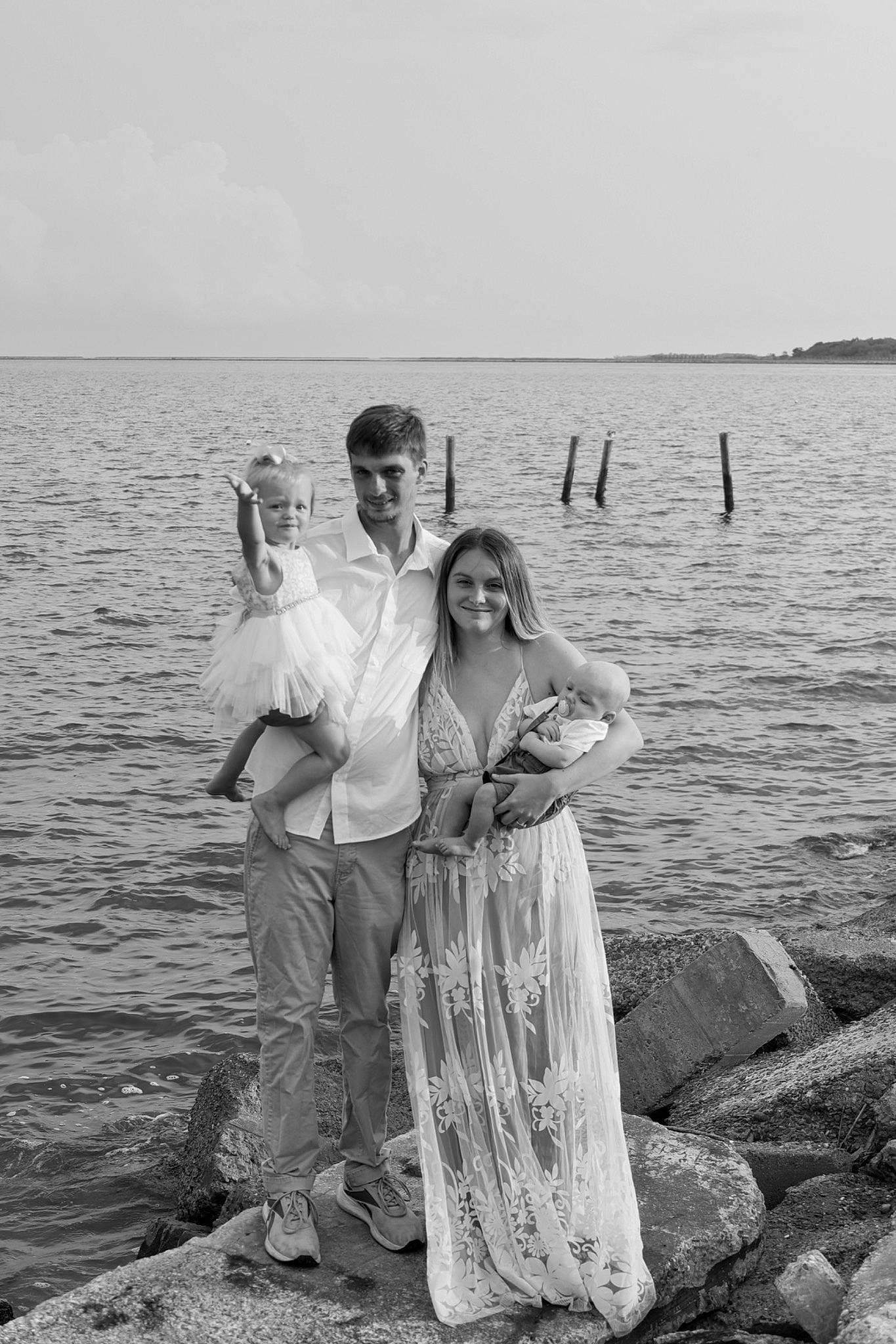 Jaxon is registered to the contest to win money with this photo: beach, black_and_white, dress, event, flash_photography, formal_wear, fun, gesture, grey, happy, joy, lake, landscape, monochrome, monochrome_photography, people, people_in_nature, person, sky, smile
