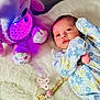 baby, beads, blanket, child, clip, colorful, comfort, cute, elephant_toy, floral_onesie, indoor, infant, lying_down, newborn, pacifier, peaceful, purple_light, soft_toy, stuffed_toy, toy