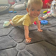Lincoln is registered to the contest to win money with this photo: toddler, child, crawling, carpet, toy, indoor, playroom, smiling, yellow_shirt, pajamas, beanbag, chair, person, floor, baby, cute, home, furniture, soft_toys, play