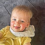 Lincoln is registered to the contest to win money with this photo: toddler, child, smiling, yellow_onesie, bib, face, blue_eyes, blond_hair, baby, happy, cheeks, tongue_out, texture, blanket, laying_down, close_up, cute, indoors, portrait, infant