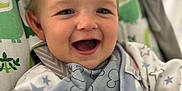 Lincoln joined the competition — help win amazing prizes! baby, smiling, child, infant, clothing, bib, face, happy, portrait, closeup, dinosaur_pattern, green, blue, stars, giraffe_patch, fabric, seated, indoors, cute, young_child